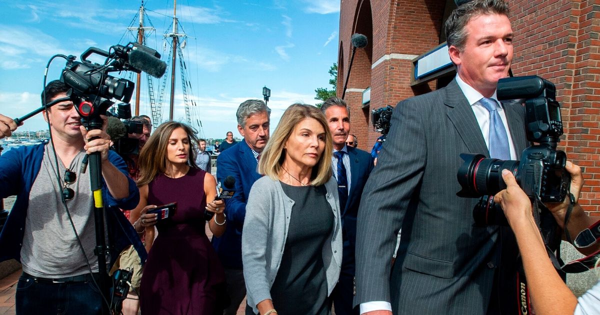 Actress Lori Loughlin, center, and husband Mossimo Giannulli, center rear, exit the courthouse after a pre-trial hearing with Magistrate Judge Kelley at the John Joseph Moakley U.S. Courthouse in Boston on Aug. 27, 2019.