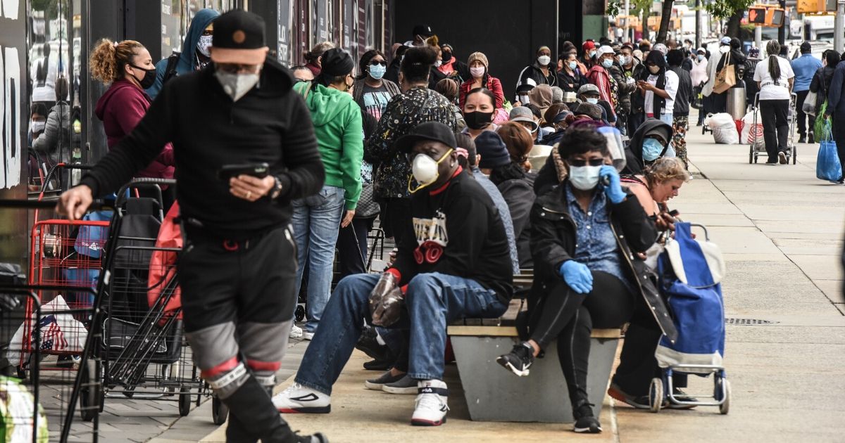 People wait in a long line to receive a food bank donation at the Barclays Center on May 15, 2020, in the Brooklyn borough of New York City.