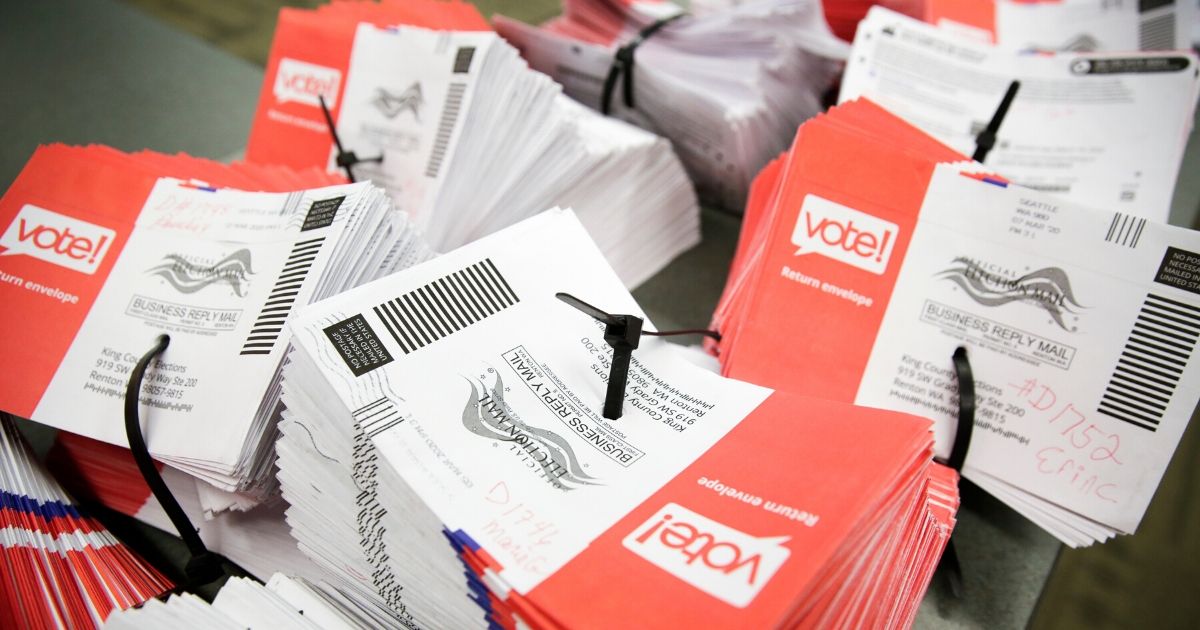 Empty envelopes of opened vote-by-mail ballots for the presidential primary are stacked on a table at King County Elections in Renton, Washington, on March 10.