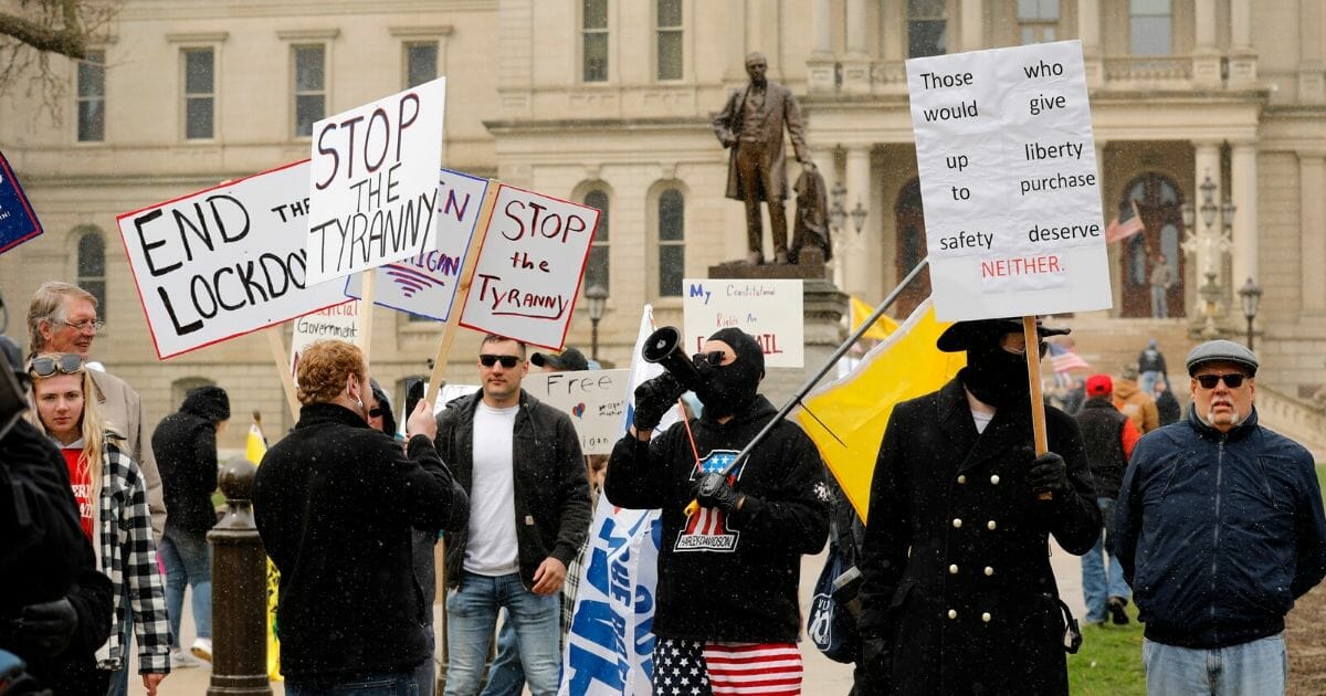 A protest organized by "Michiganders Against Excessive Quarantine" gathers around the Michigan State Capitol in Lansing on April 15, 2020.