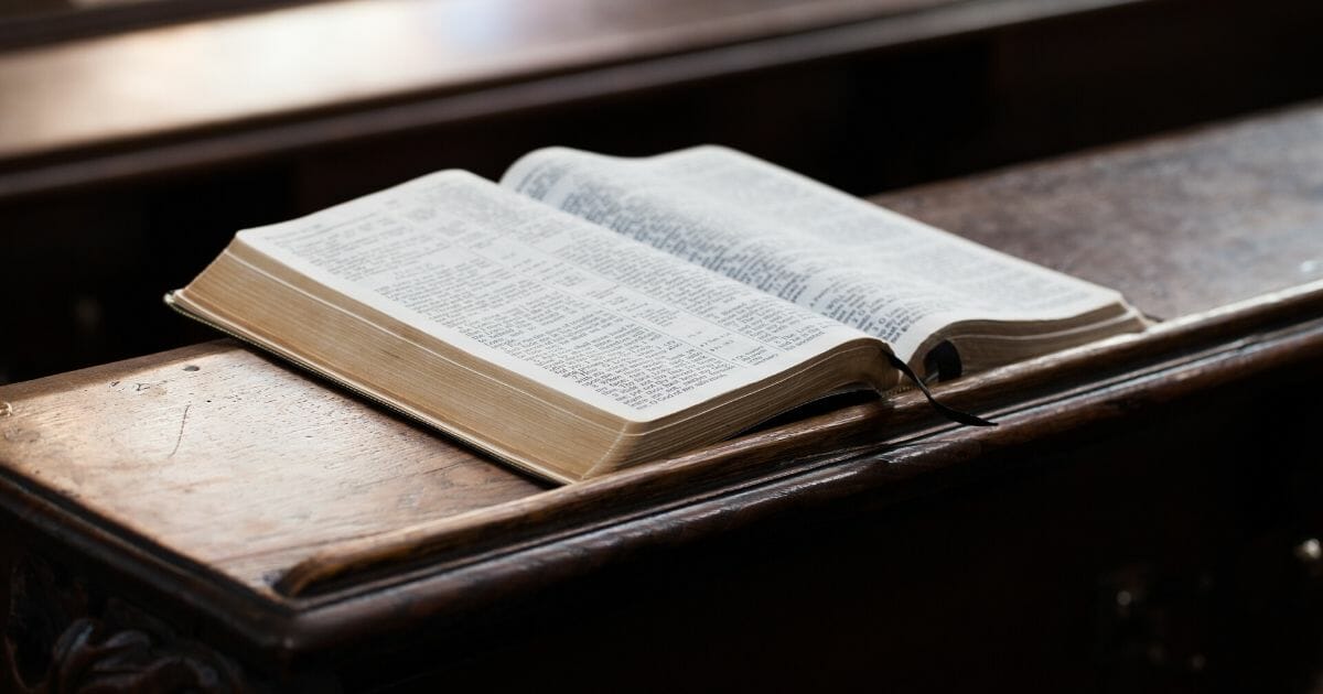 Stock image of a Bible on a church pew.