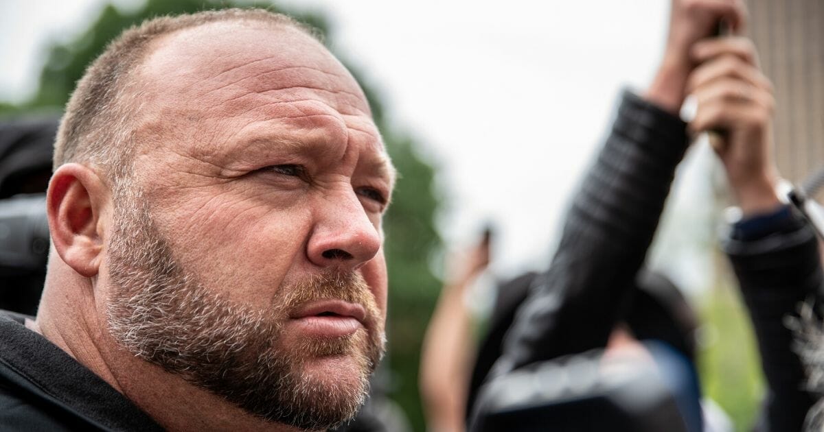 Conspiracy theorist and Infowars founder Alex Jones listens to a supporter at the Texas state Capitol on April 18, 2020, in Austin, Texas.