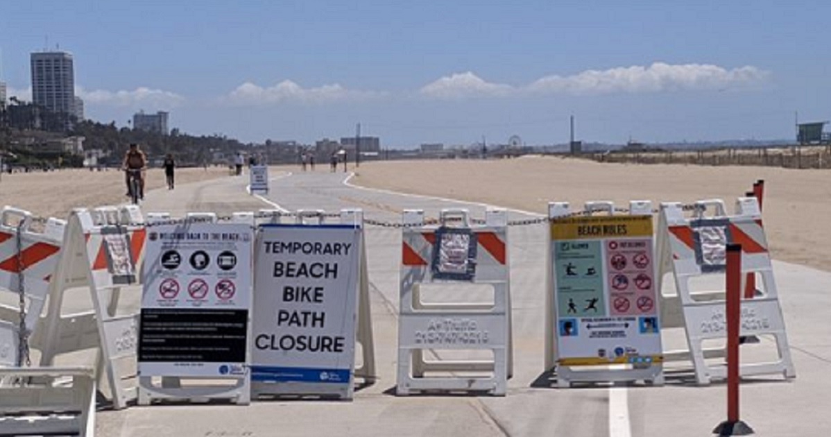 Signs inform visitors that Los Angeles County beaches had been closed by the coronavirus pandemic. The beaches were reopened for Memorial Day weekend.