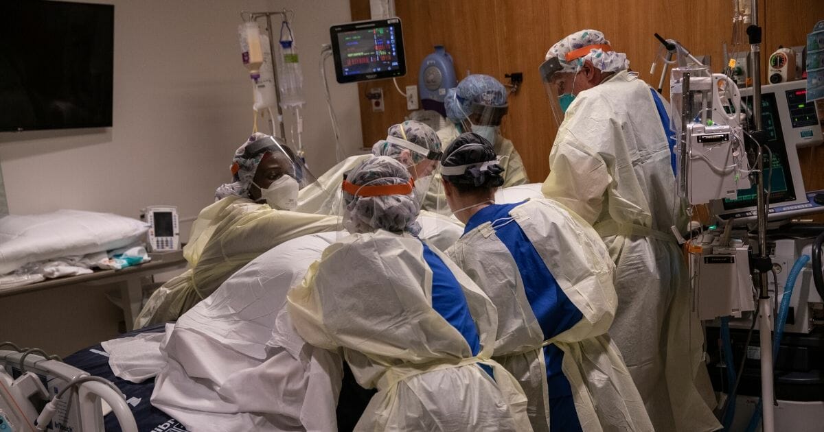 A "prone team," wearing personal protective equipment, turns a COVID-19 patient onto his stomach in a Stamford Hospital intensive care unit on April 24, 2020, in Stamford, Connecticut.