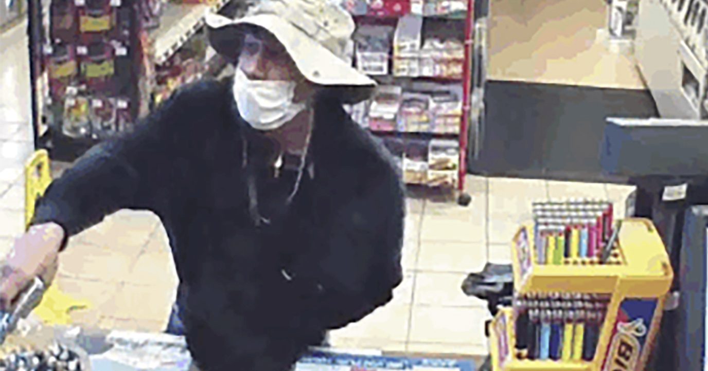 This March 26, 2020, image from surveillance video shows a man, believed to be William Rosario Lopez wearing a surgical mask, with a gun in a Connecticut convenience store. Just how many criminals are taking advantage of the pandemic to commit crimes is impossible to estimate, but law enforcement officials have no doubt that the numbers are climbing. Reports are starting to pop up across the country, as well as in other parts of the world of crimes that were pulled off in no small part because so many of us are wearing masks.