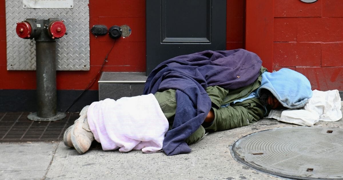 A homeless person sleeps near Madison Square Garden