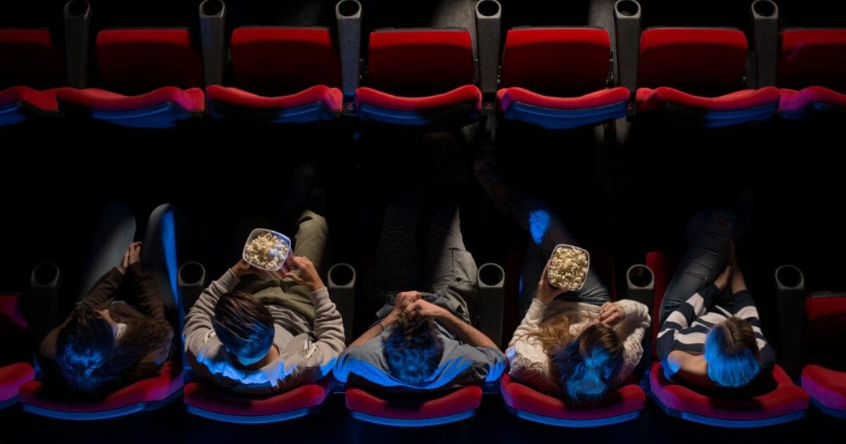 People sit in a movie theater in the stock image above.