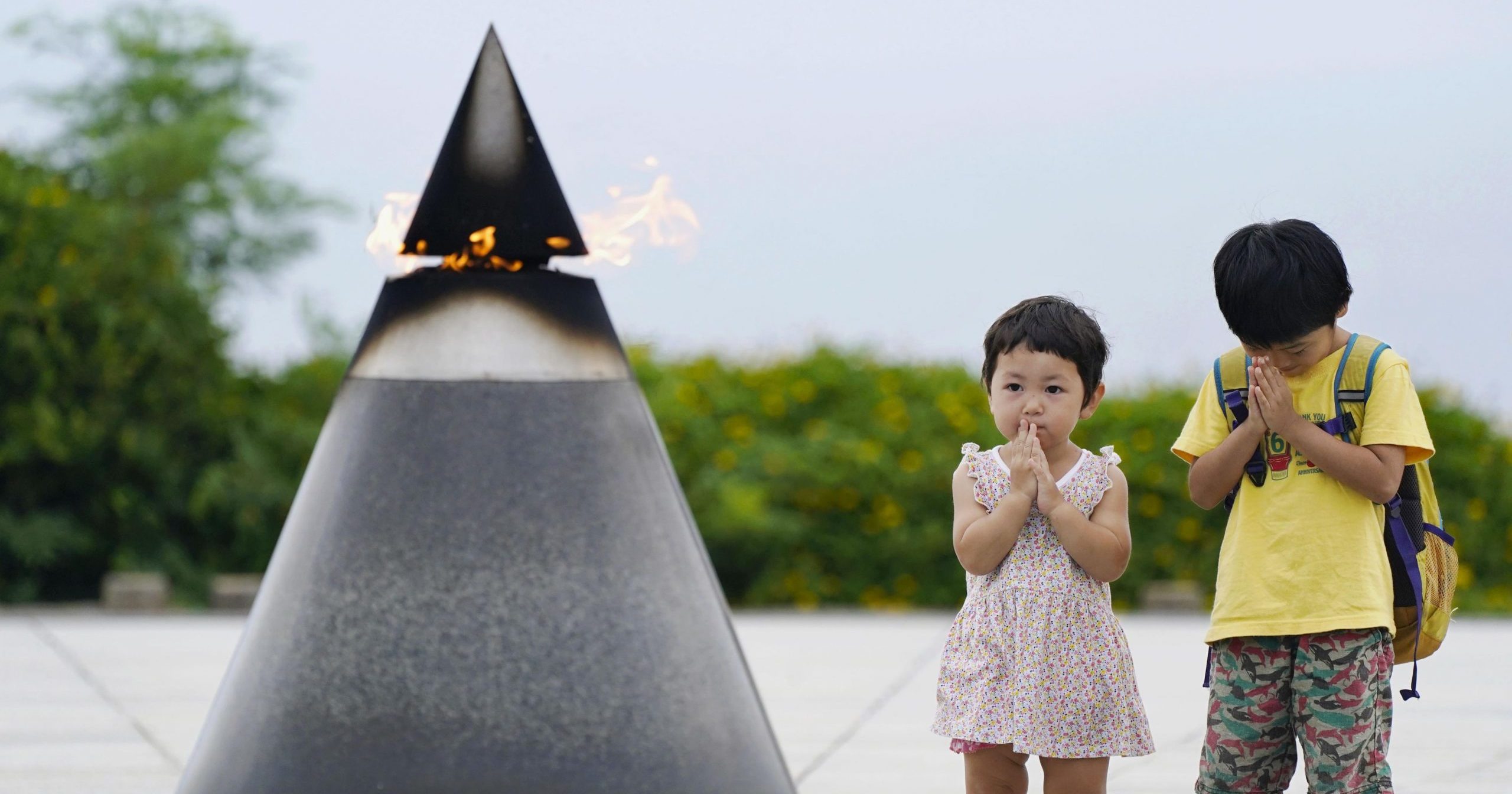 Children pray in front of the "Peace of Fire" at the Peace Memorial Park in Itoman, Okinawa, Japan, on June 23, 2020, 75 years after the Battle of Okinawa.