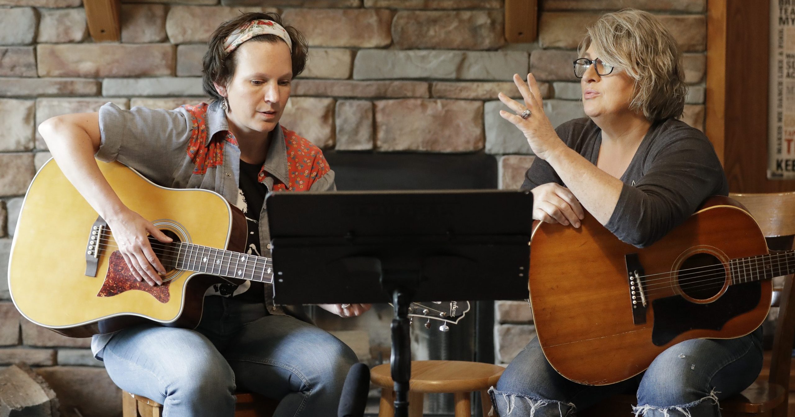 In this May 22, 2020, photo, nurse Megan Palmer, left, and care partner Anna Henderson, who both work at Vanderbilt University Medical Center, are seen during a songwriting session at Henderson's home in Ashland City, Tennessee. During the coronavirus pandemic, their role as caregivers has become even more important as hospital visits from family and friends are limited or prohibited.