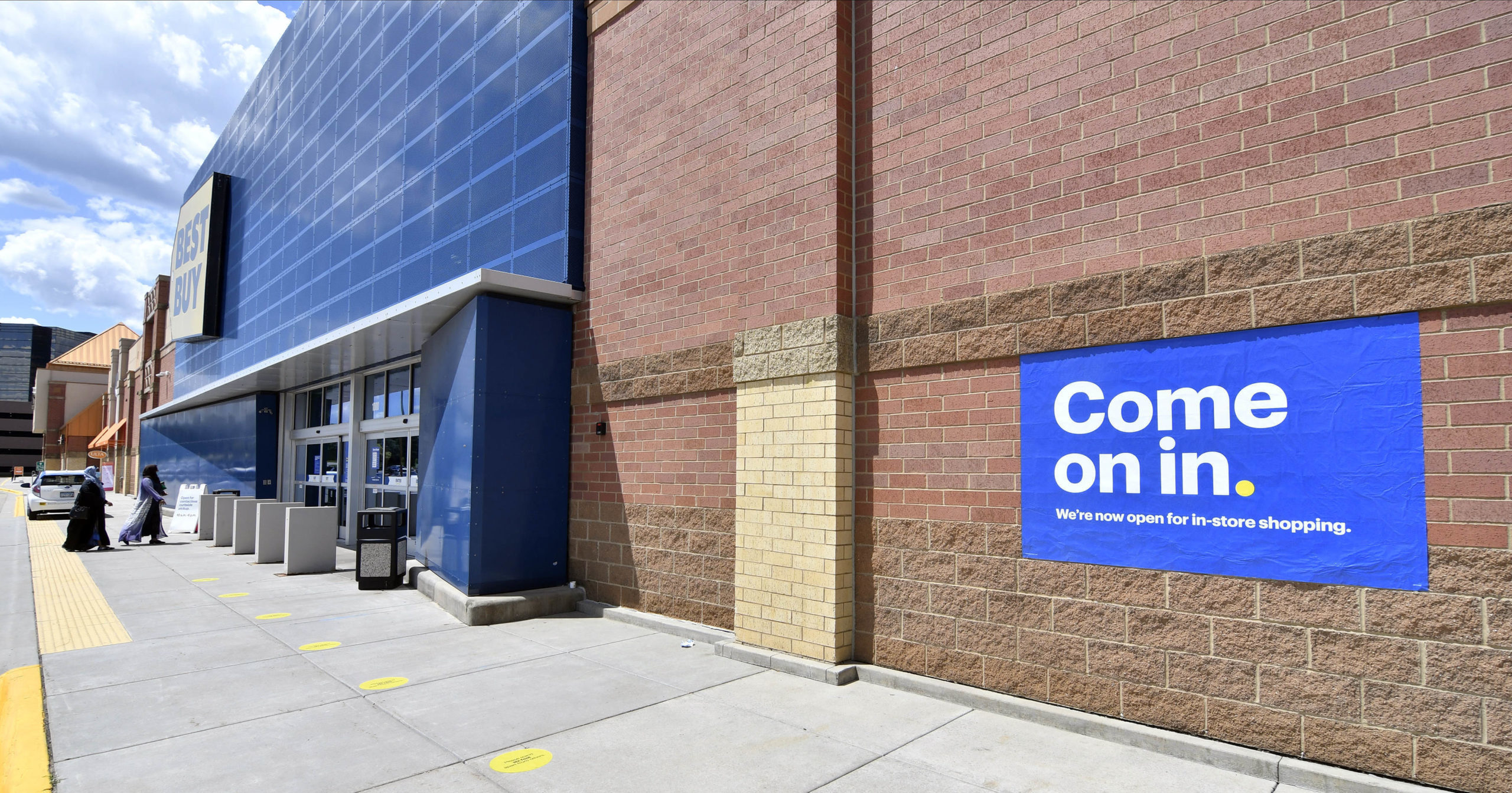 Shoppers head to the entrance as a sign invites customers to shop inside a Best Buy store on June 24, 2020, in Richfield, Minnesota. Restrictions due to the coronavirus have eased in Minnesota.