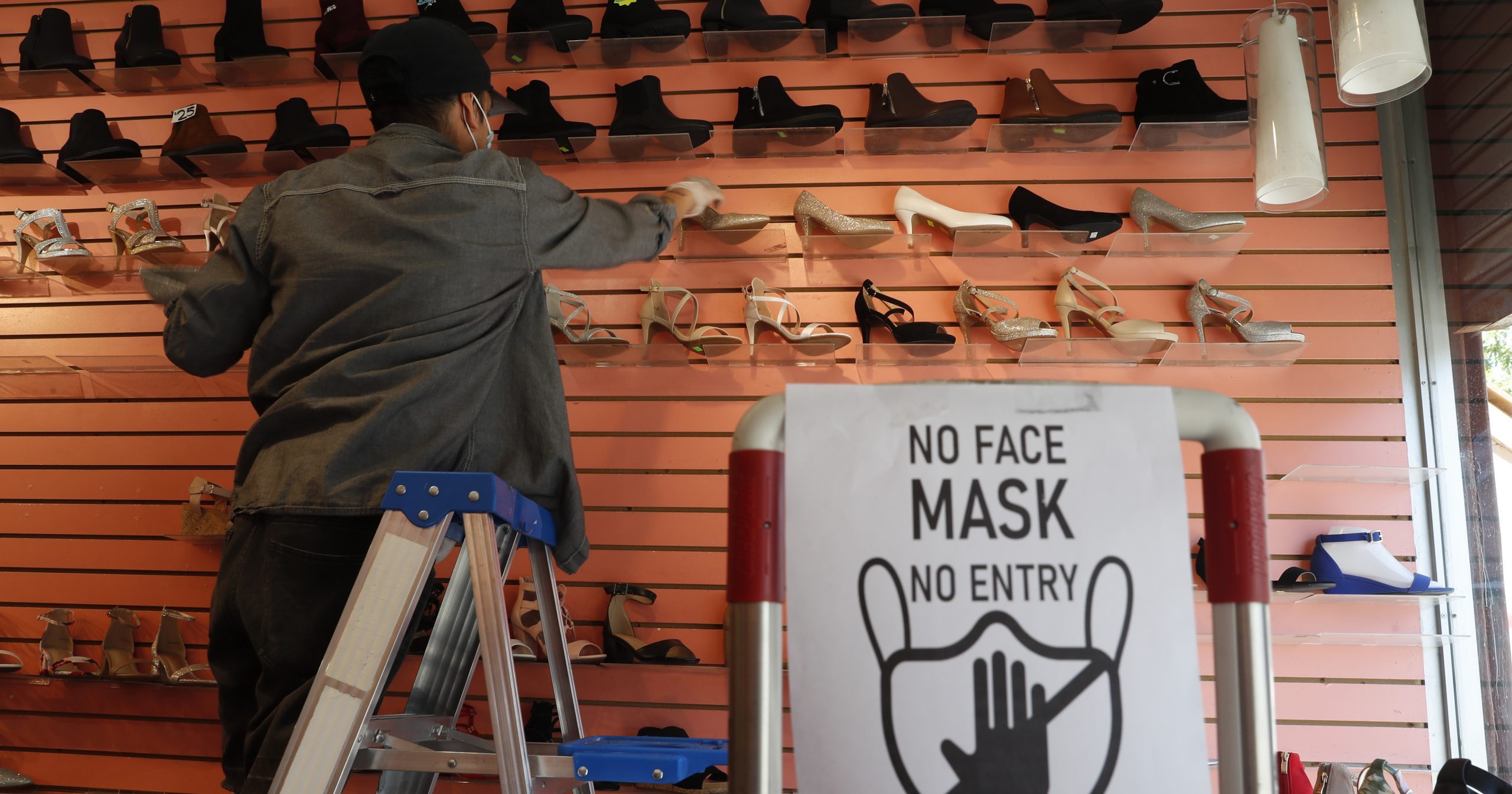 Manager Angel Ramos arranges shoes on a display in Top Shoes in the Brooklyn borough of New York on, June 8, 2020.