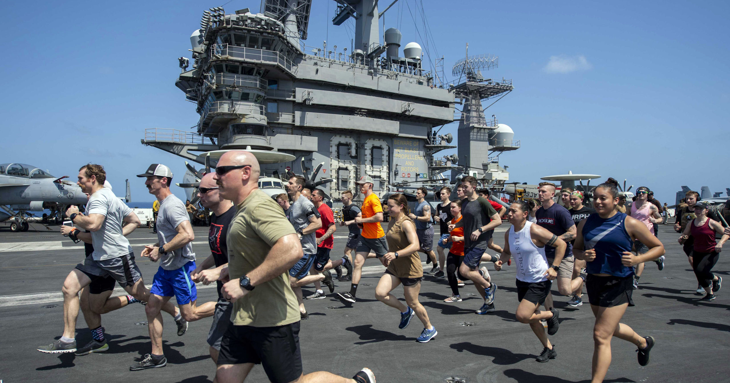 Sailors run on the flight deck of the aircraft carrier USS Dwight D. Eisenhower on May 24, 2020.