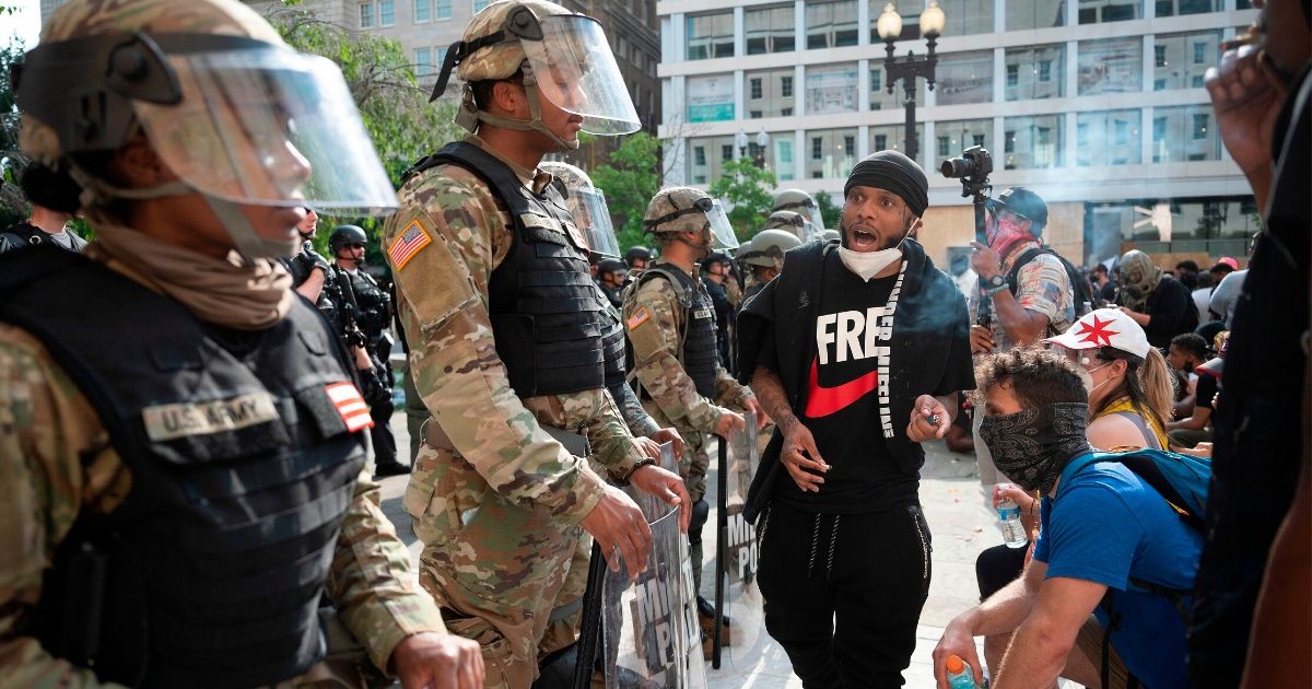 A protester yells at Army National Guard members as he and others demonstrate the death of George Floyd near the White House on June 3, 2020, in Washington, D.C.