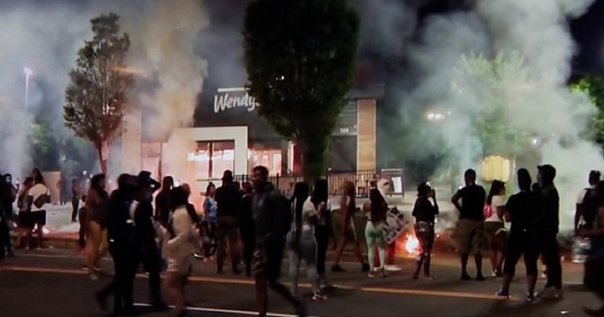 A crowd is gathered outside a Wendy's restaurant in Atlanta that was set on fire Saturday night amid a demonstration over the shooting death of a black man who fought with officers during an arrest Friday night.