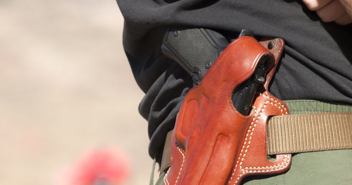 A gun is seen in a holster in the stock image above.