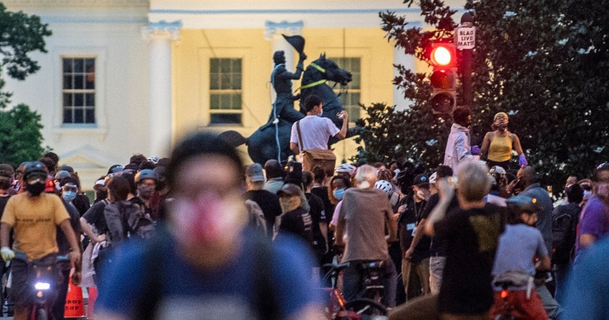 Demonstrators and police officers surround the equestrian statue of former President Andrew Jackson in Washington's Lafayette Square, in front of the White House, after protesters tried to topple it on June 22, 2020.