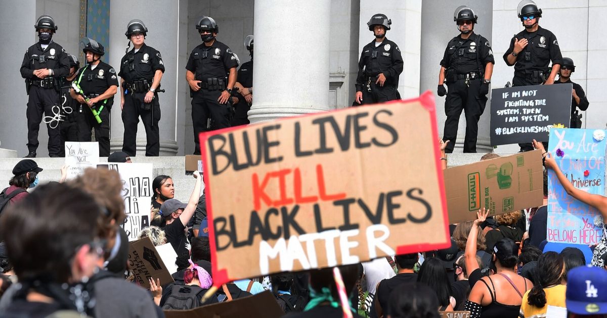 Protesters hold anti-police placards during a demonstration in front of Los Angeles City Hall on June 1, 2020.