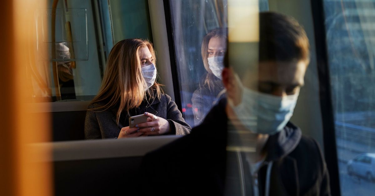 People wear face masks on a train in the stock image above.