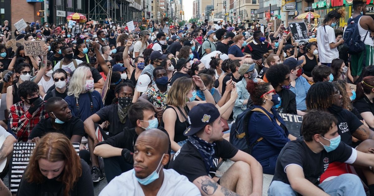 Protesters sit in 42nd Street near Times Square in New York on June 7, 2020, as they demonstrate over the death of George Floyd in Minneapolis police custody.