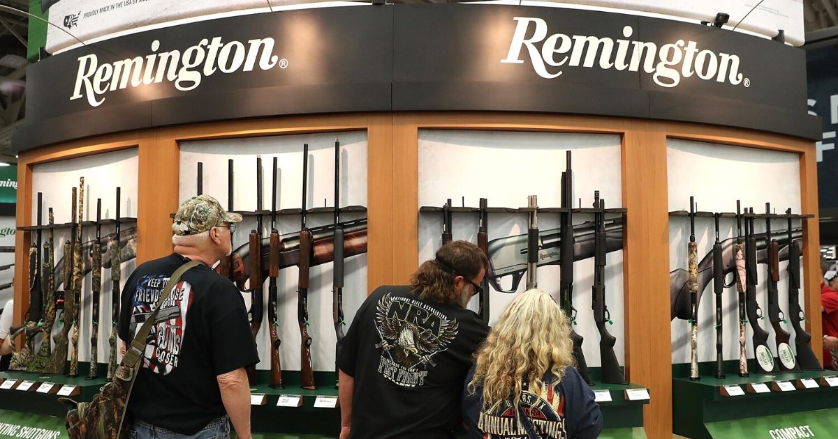 Attendees look at a display of Remington shotguns