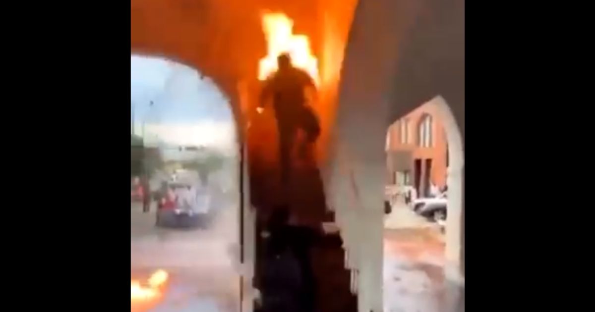 A rioter catches himself on fire while trying to burn down a building in Fayetteville, North Carolina.