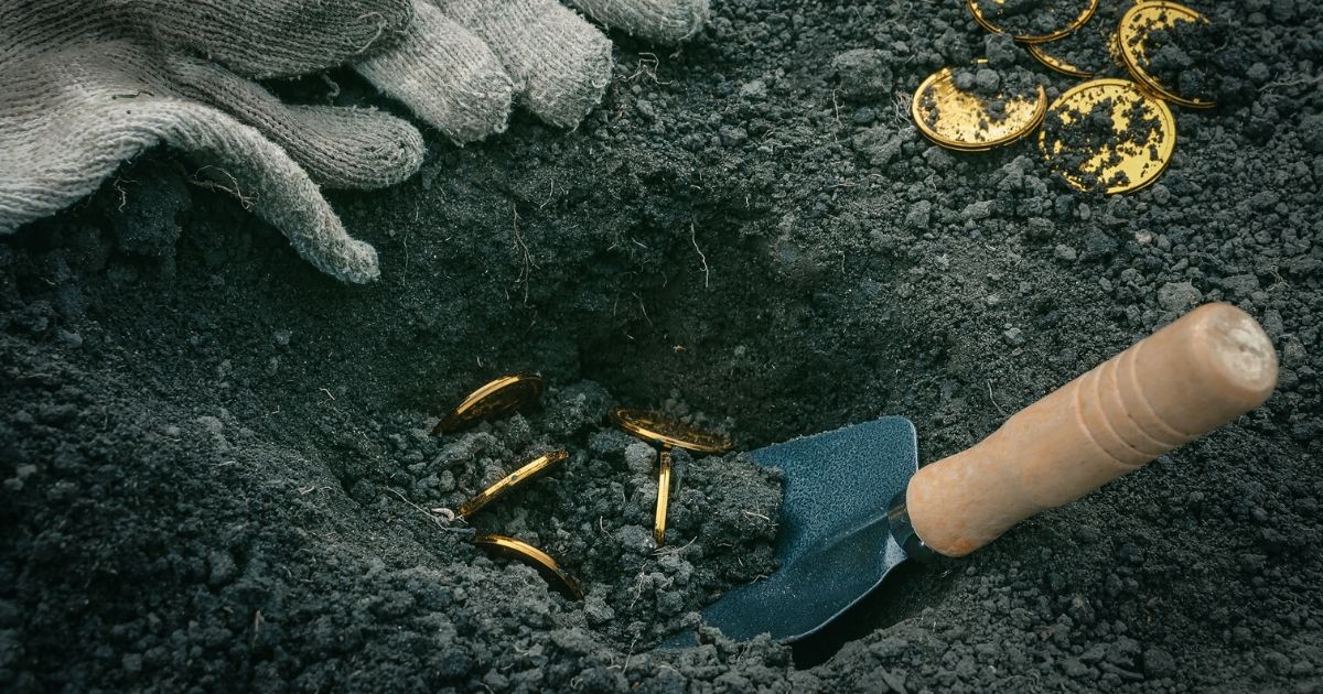 A person digs up golden coins.