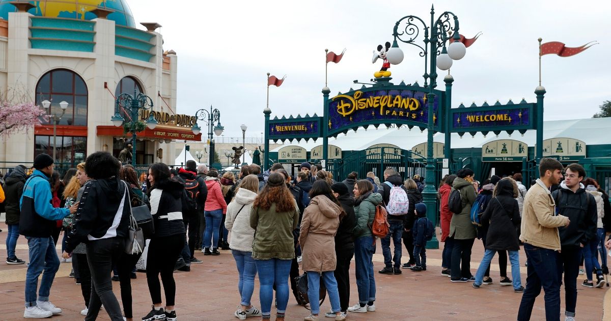People line up to enter Disney stores in the Disney Village district as Disneyland Paris joins the closure of Disney parks around the world amid coronavirus concerns on March 14, 2020, in Paris.