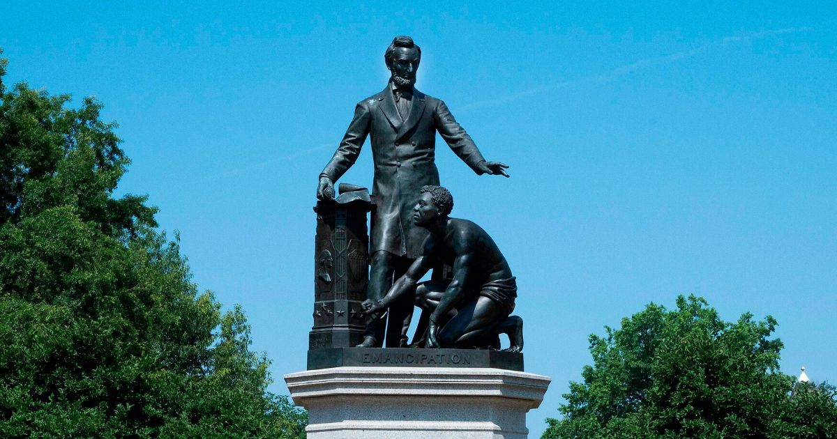 A child roller blades past the Lincoln Park Emancipation Memorial, a statue that depicts former President Abraham Lincoln standing over a kneeling freed African-American man, in Washington, D.C., on June 22, 2020.