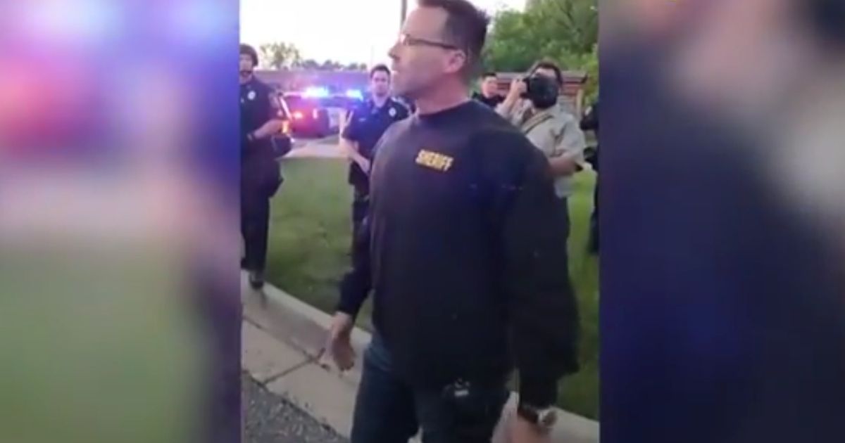 Sheriff Chris Swanson of Genesee County in Michigan speaks to protesters after setting down his riot gear.