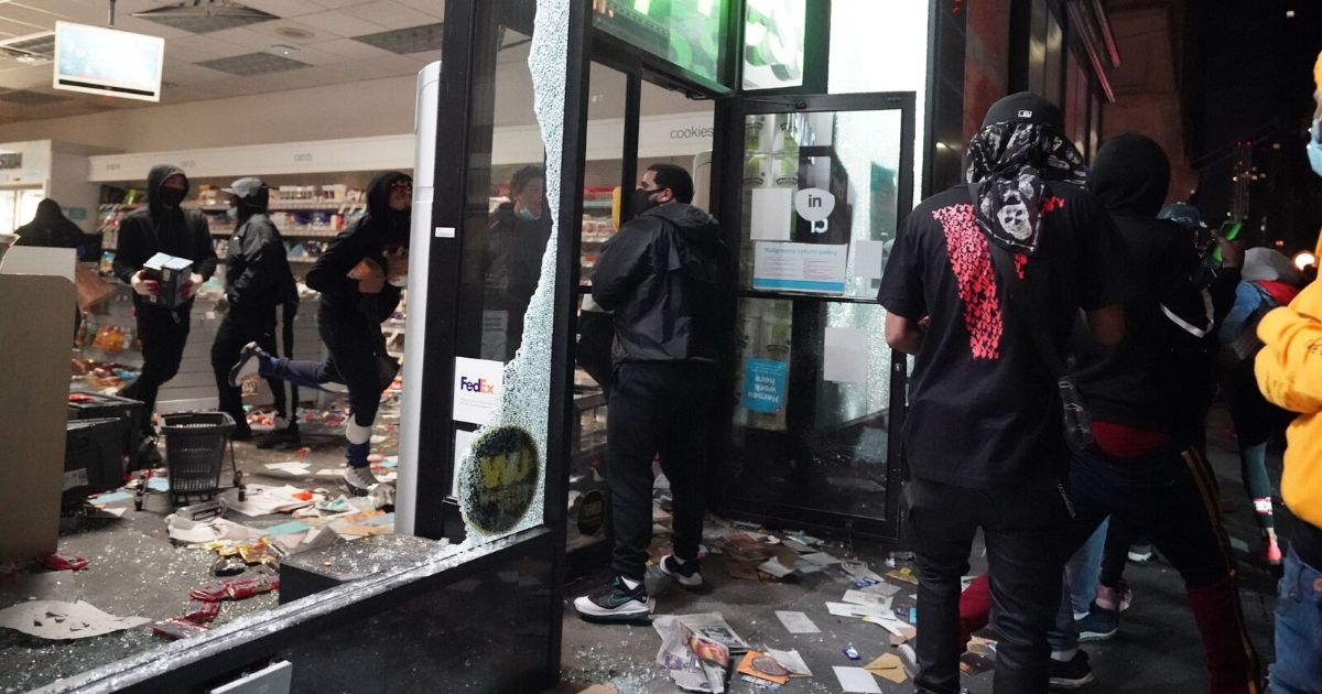 Looters sack a store in New York City on Monday after its windows and doors were shattered.