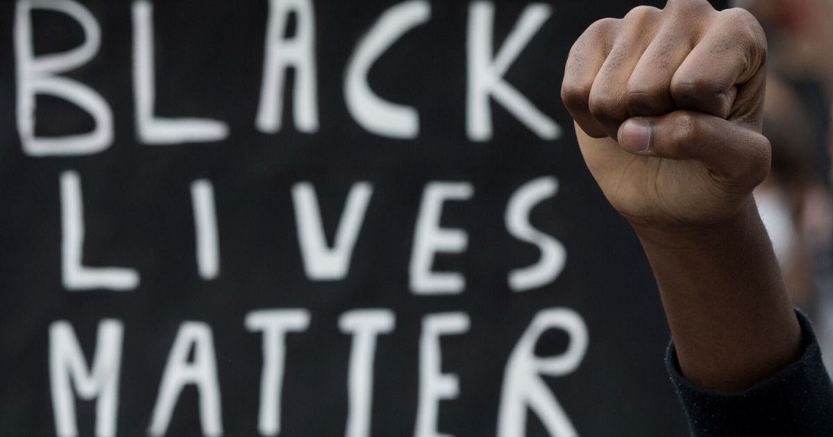 A protester raises a fist next to a placard in Nantes, France, on June 8, 2020, during a "Black Lives Matter" protest.