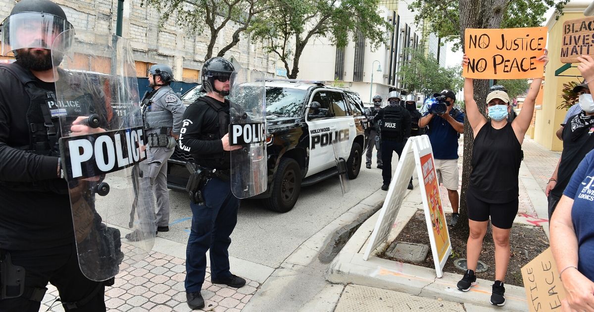 Police in riot gear look on during a protest on June 7, 2020, in Hollywood, Florida.
