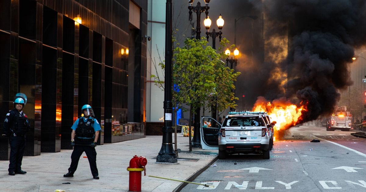 A vehicle set on fire explodes during riots on May 30, 2020, in Chicago.