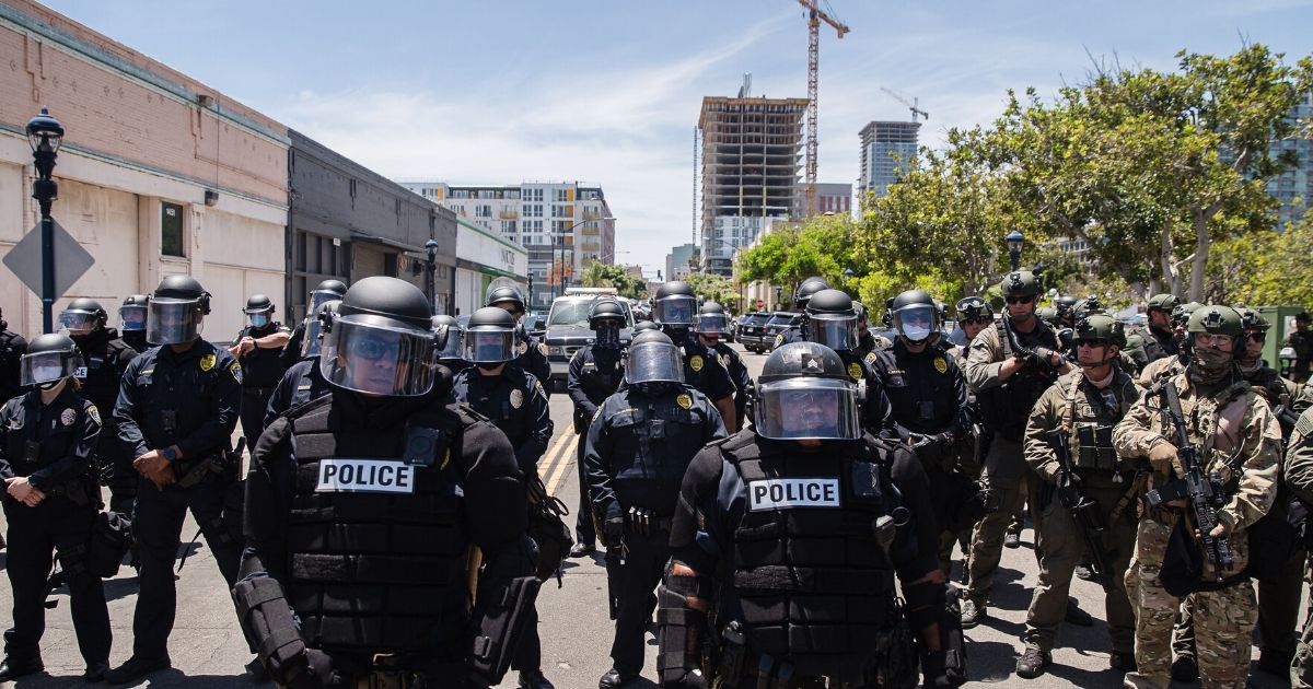 San Diego Police officers in riot gear and a special tactics group face off with demonstrators in downtown San Diego on May 31, 2020.
