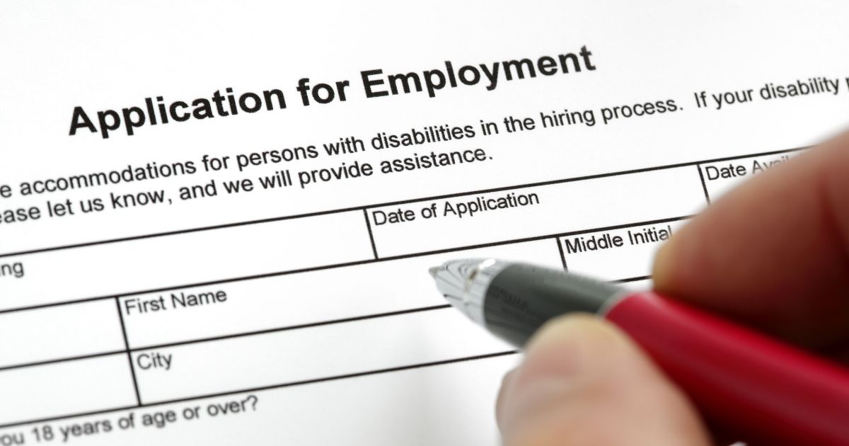 Stock image of a person filling out a job application form.