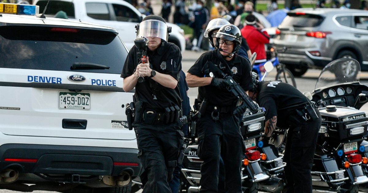 A police officer aims a pepper ball gun during a protest on May 29, 2020, in Denver.