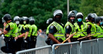 Police officers in riot gear stand guard outside the State House in Boston on June 27, 2020.