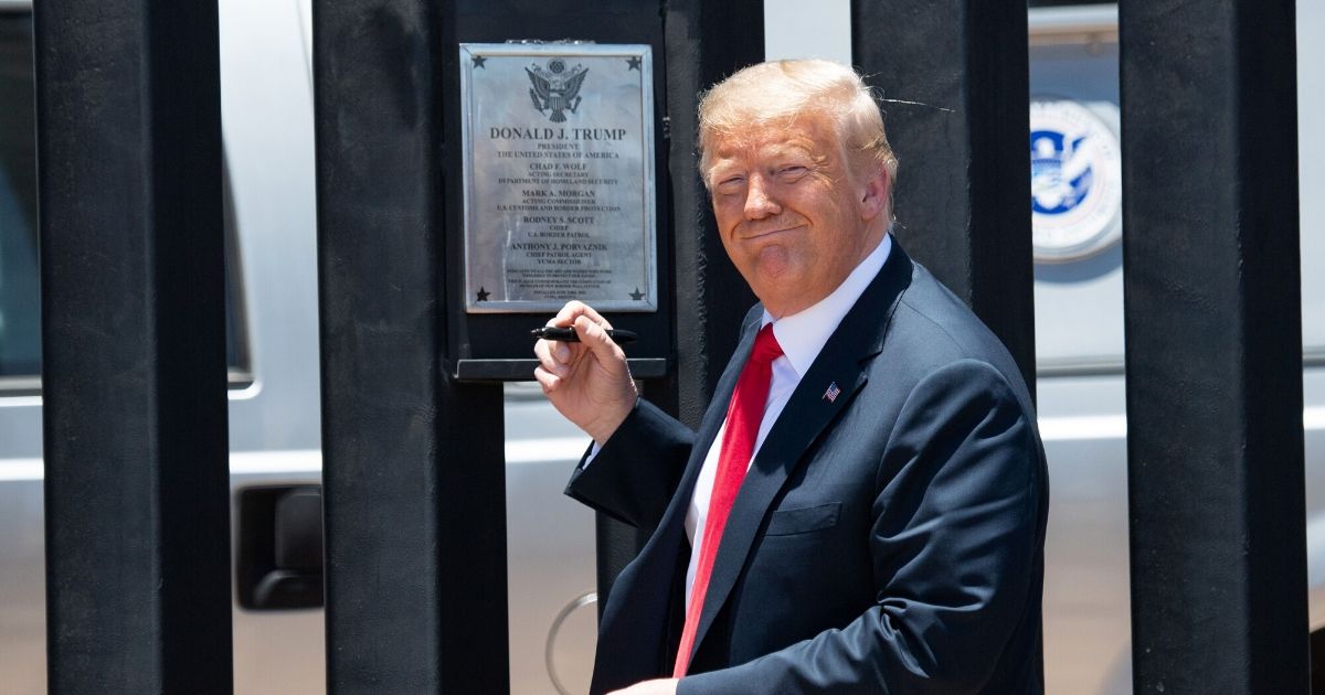 President Donald Trump signs a plaque as he participates in a ceremony commemorating the 200th mile of border wall at the international border with Mexico in San Luis, Arizona, on June 23, 2020.