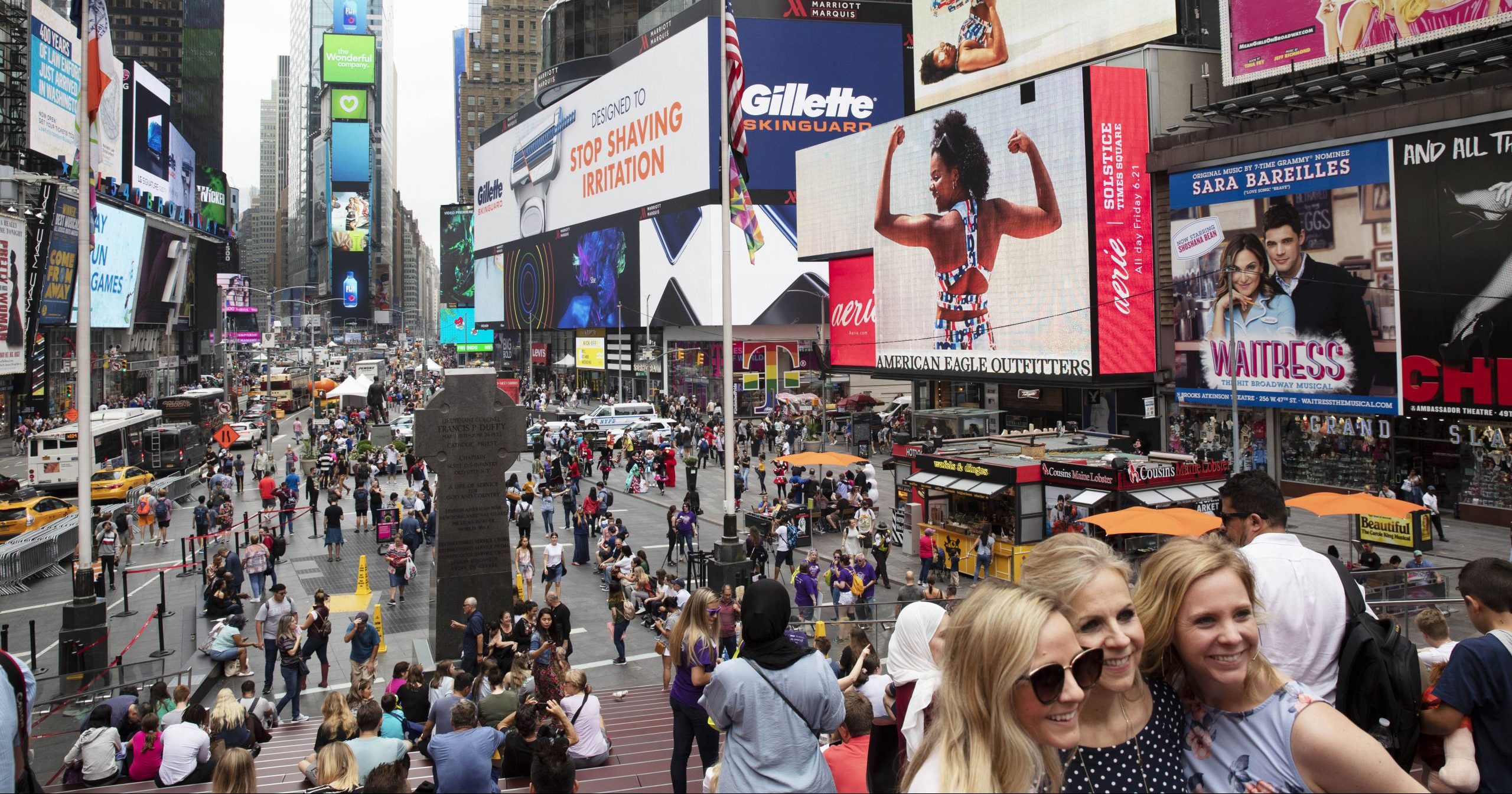 In this June 20, 2019, file photo, tourists visit Times Square in New York. After three months of a coronavirus crisis followed by protests and unrest, New York City is trying to turn a page as a limited range of industries reopen Monday, June 8, 2020.