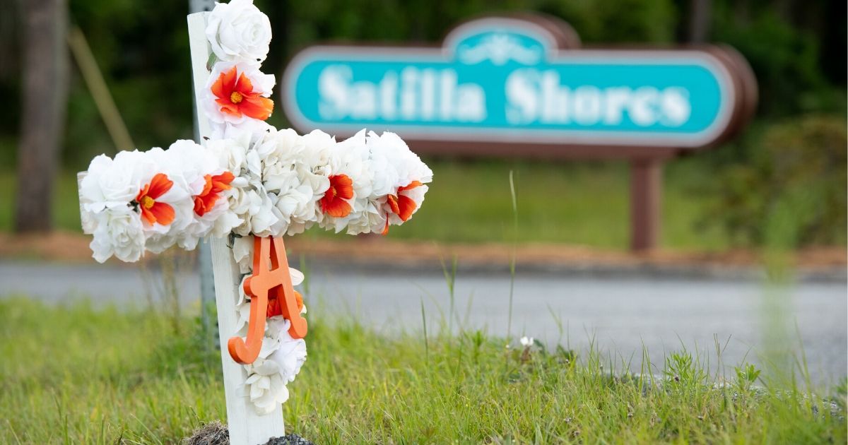 A cross with flowers and a letter "A" sits at the entrance to the Satilla Shores neighborhood where Ahmaud Arbery was shot and killed on May 6, 2020, in Brunswick, Georgia.