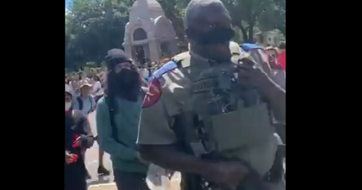 A Texas State Police trooper is harassed by a mob of protesters outside the Texas Capitol on Thursday.