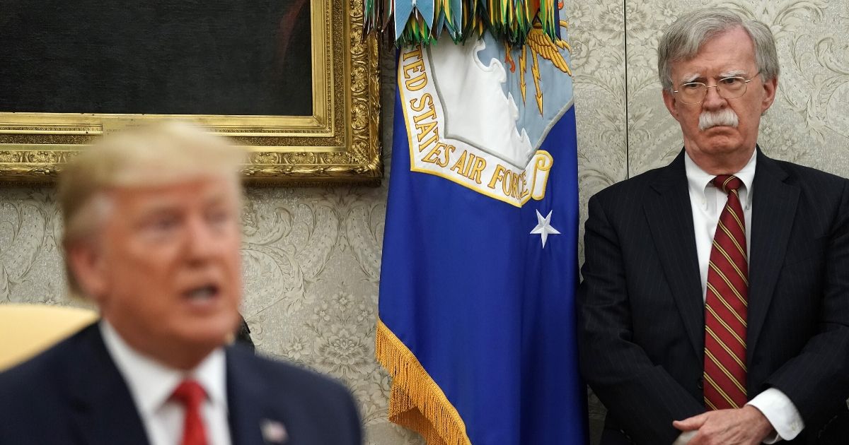 Former national security adviser John Bolton listens to President Donald Trump in the Oval Office at the White House on July 18, 2019, in Washington, D.C.