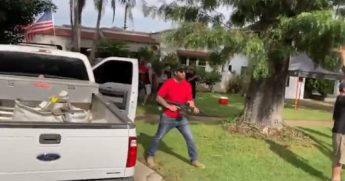 A California man holds a rifle on a lawn during a protest in San Bernardino County on Monday.
