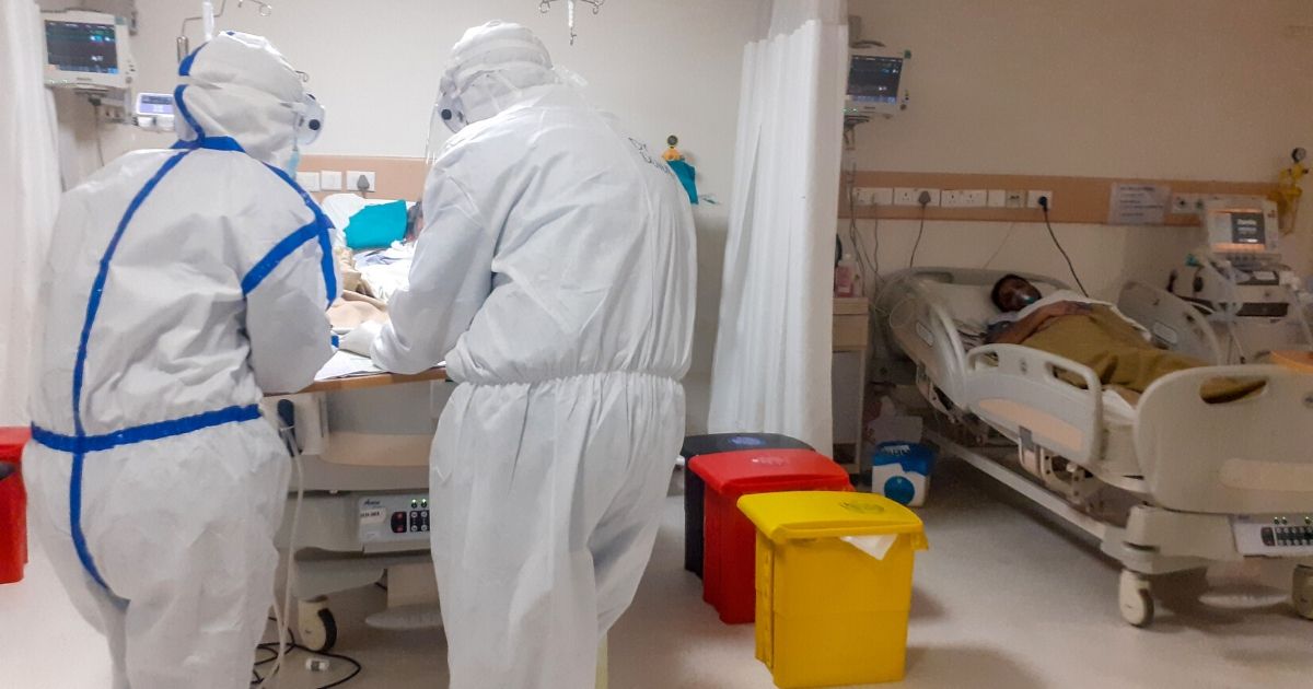 This picture taken on June 9, 2020, shows medical workers wearing personal protective equipment checking on a COVID-19 coronavirus patient in the intensive care unit of Max Smart Super Speciality Hospital in New Delhi.