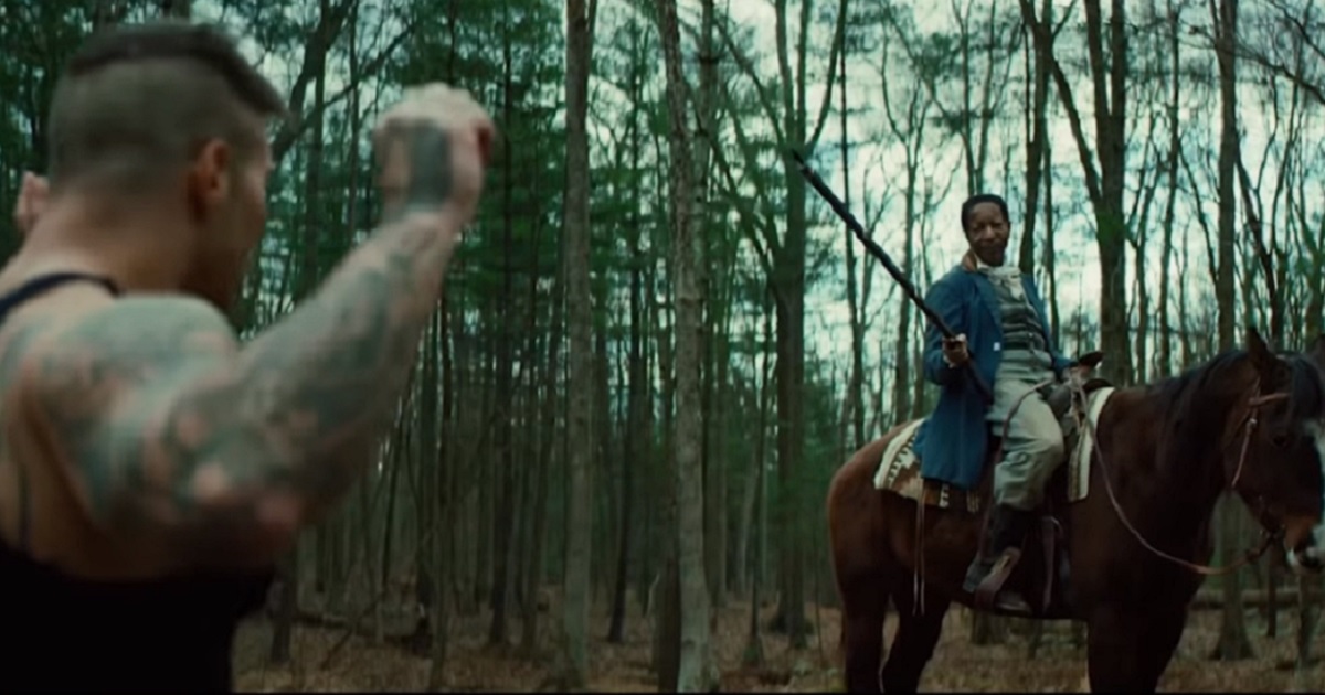 A black man on a horse holds a white man at gunpoint in a scene from the alternate-reality movie "Cracka."