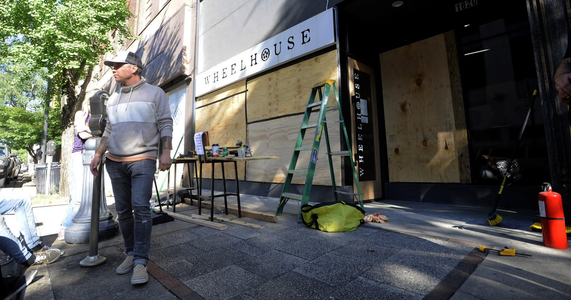 Owner Johnny Grimes stands outside his salon on June 1, 2020, in Birmingham, Alabama, as he works to board up the windows after it was vandalized and looted.