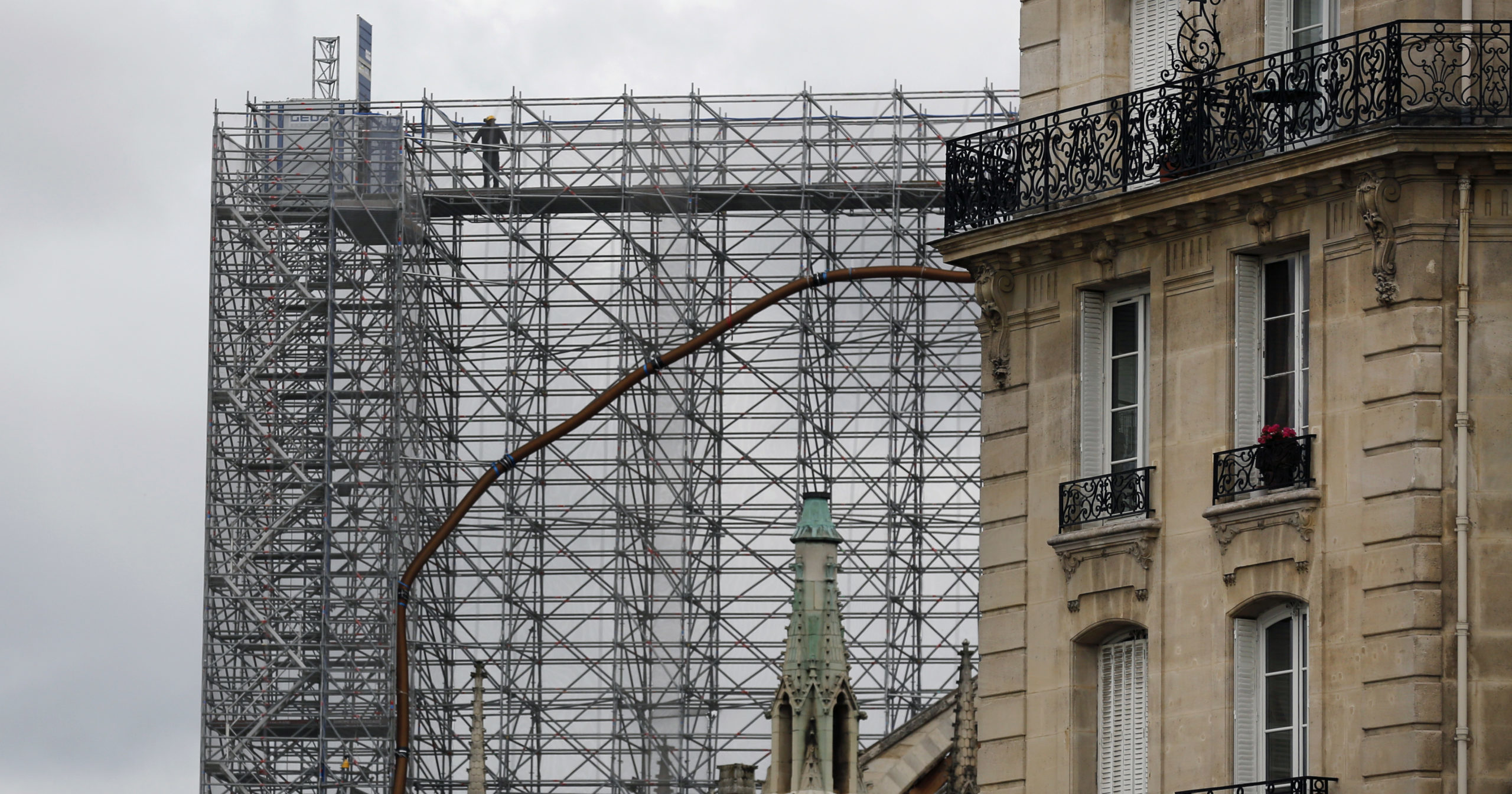 A worker stands on scaffolding at Notre Dame Cathedral on July 10, 2020, in Paris. Notre Dame will be rebuilt just the way it stood before last year's devastating fire.