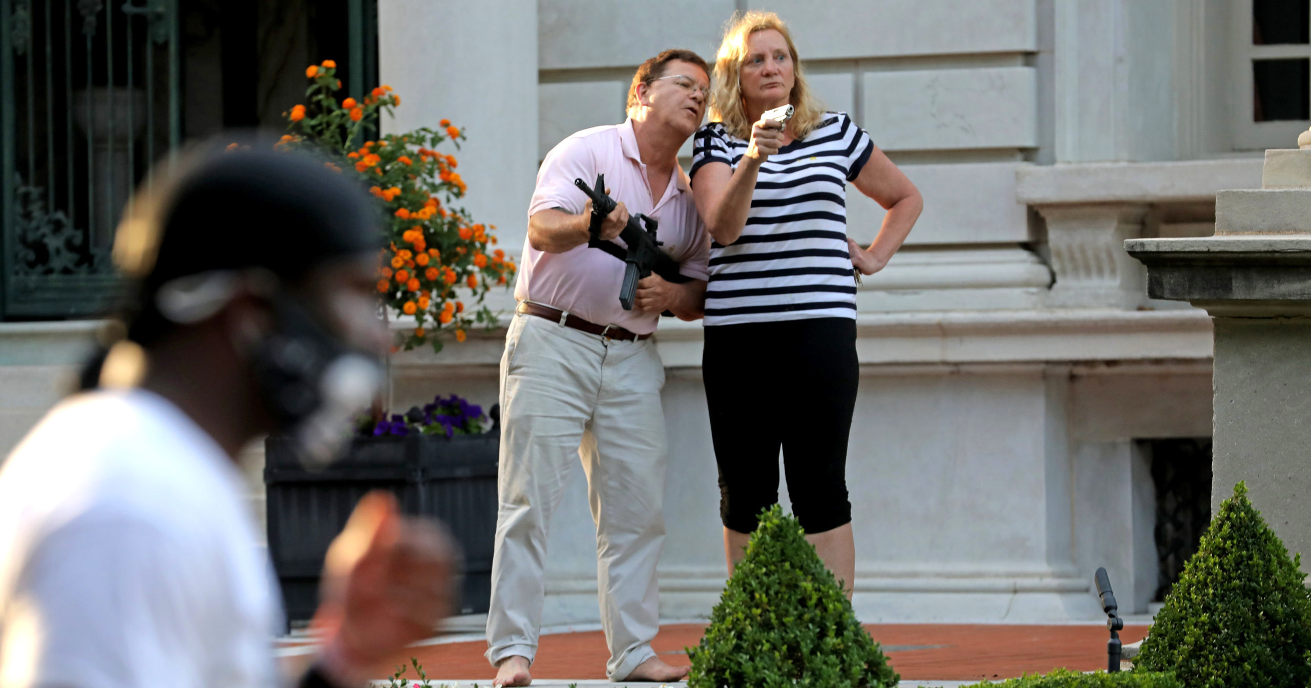 In this June 28, 2020, file photo, armed homeowners Mark and Patricia McCloskey confront protesters outside their home in St. Louis. President Donald Trump believes St. Louis’ top prosecutor committed an “egregious abuse of power” in charging the couple, White House press secretary Kayleigh McEnany said on July 21.