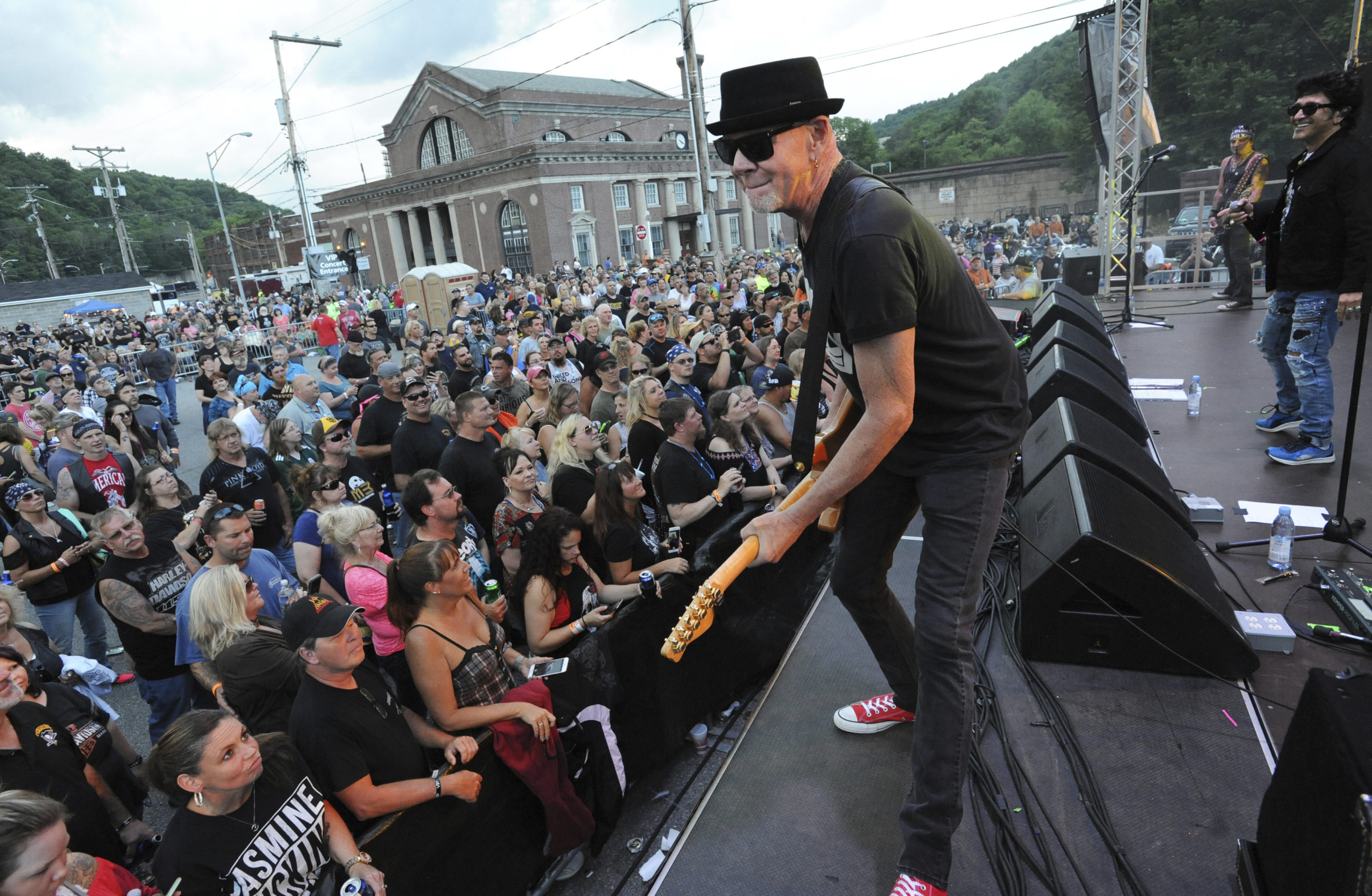 Mark Kendall, center, with the band Great White, performs in Johnstown, Pennsylvania, in June 2018. Great White, a metal band, has apologized for performing at an outdoor North Dakota concert where crowd members did not wear face masks amid the coronavirus pandemic.