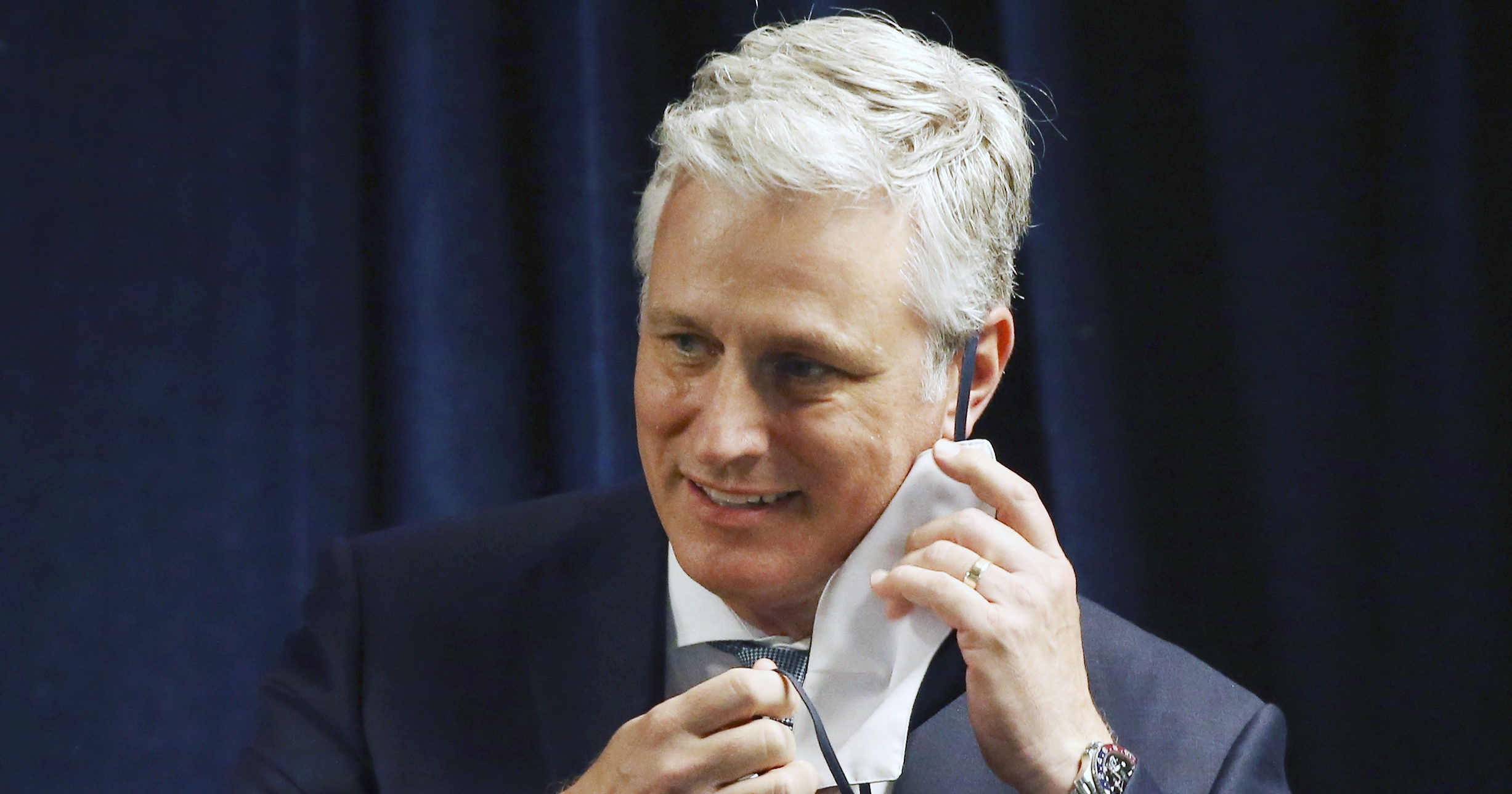 Robert O'Brien removes a face covering prior to speaking during a news conference in Phoenix on June 24, 2020.